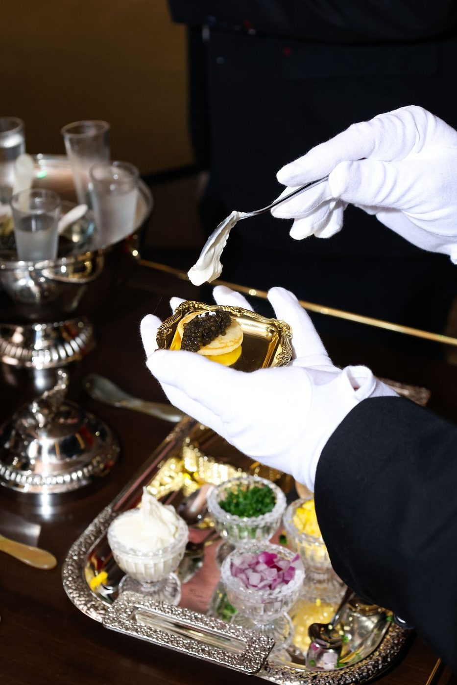 White gloved server spooning caviar